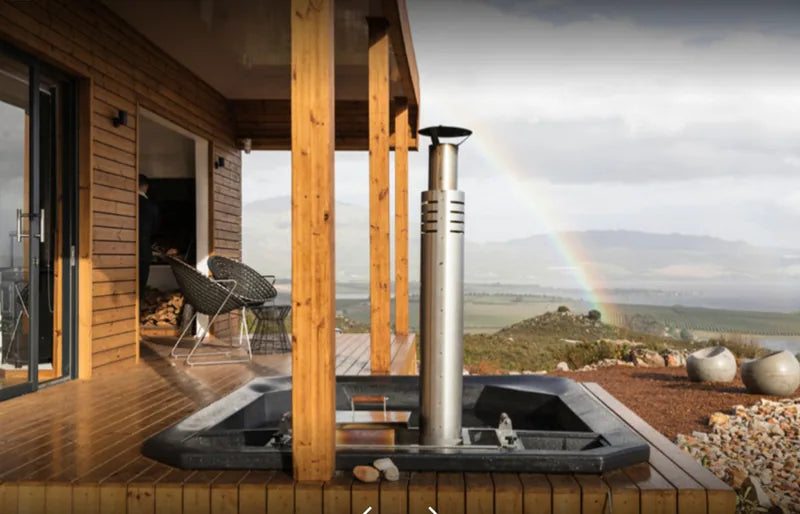 36m² 1-Bedroom Container House — Insulated Standard Configuration — supplier gallery view 3; Container house deck with a wood-fired hot tub beneath the veranda and a rainbow over the surrounding landscape