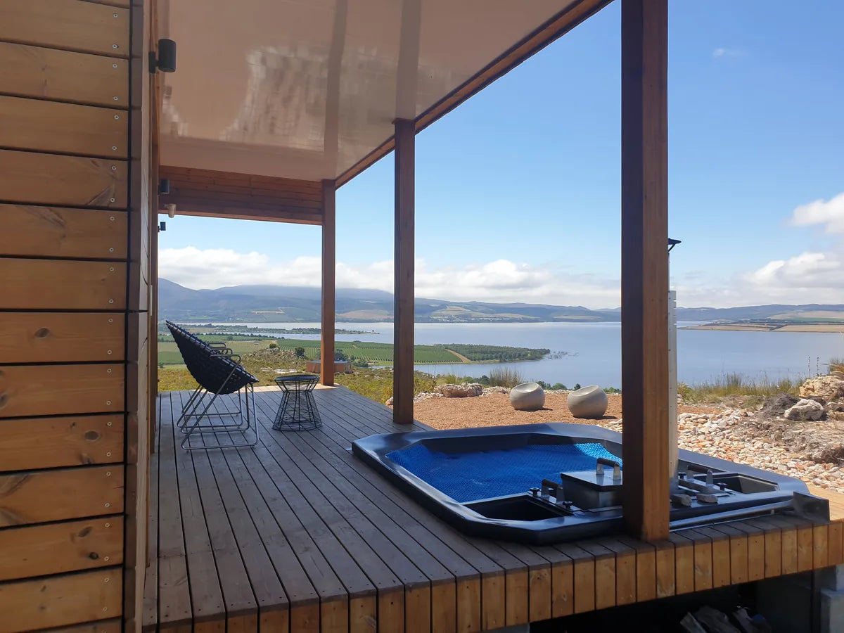 36m² 1-Bedroom Container House — Insulated Standard Configuration — supplier gallery view 4; Covered container house veranda with a plunge pool and chair, looking across the water towards distant hills